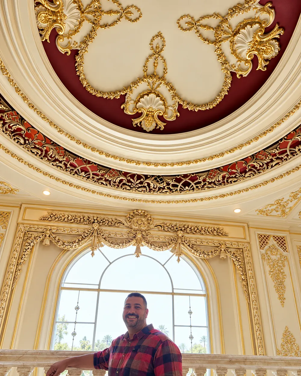 Gilded dome and arched window framed in red and gold ornament