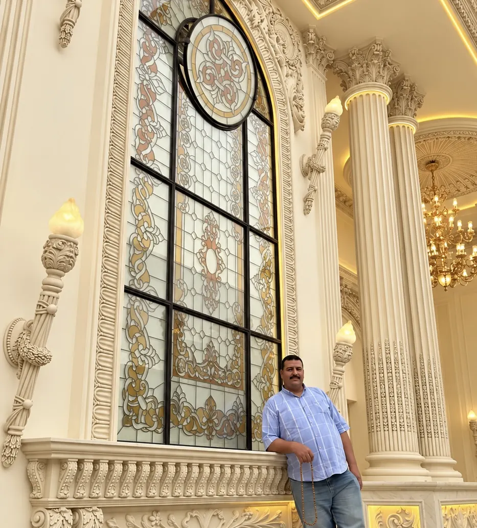 Columns and a stained-glass window in a gilded hall